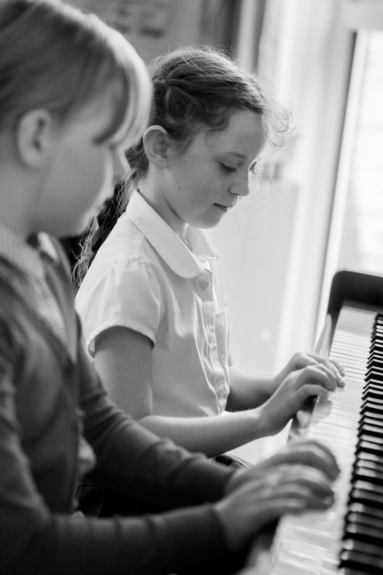 two children playing piano